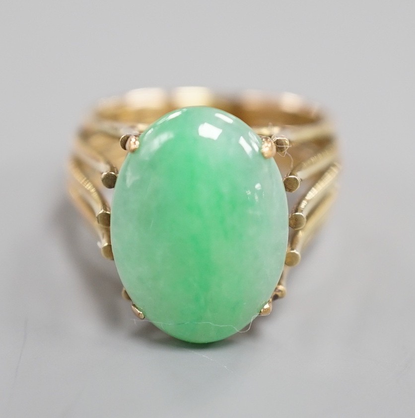 A 585 yellow metal and cabochon jade set oval dress ring, size P/Q, gross weight 8.4 grams.